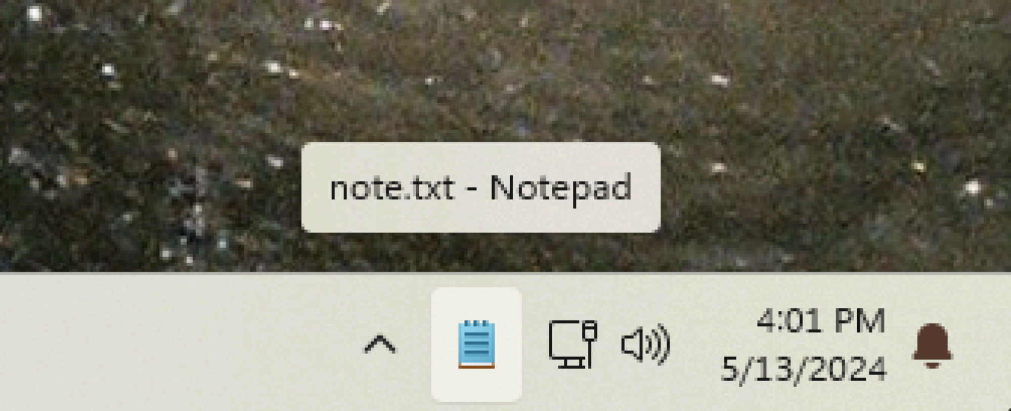 The notepad icon visible in the system tray, accompanied by a tooltip stating 'note.txt notepad'.