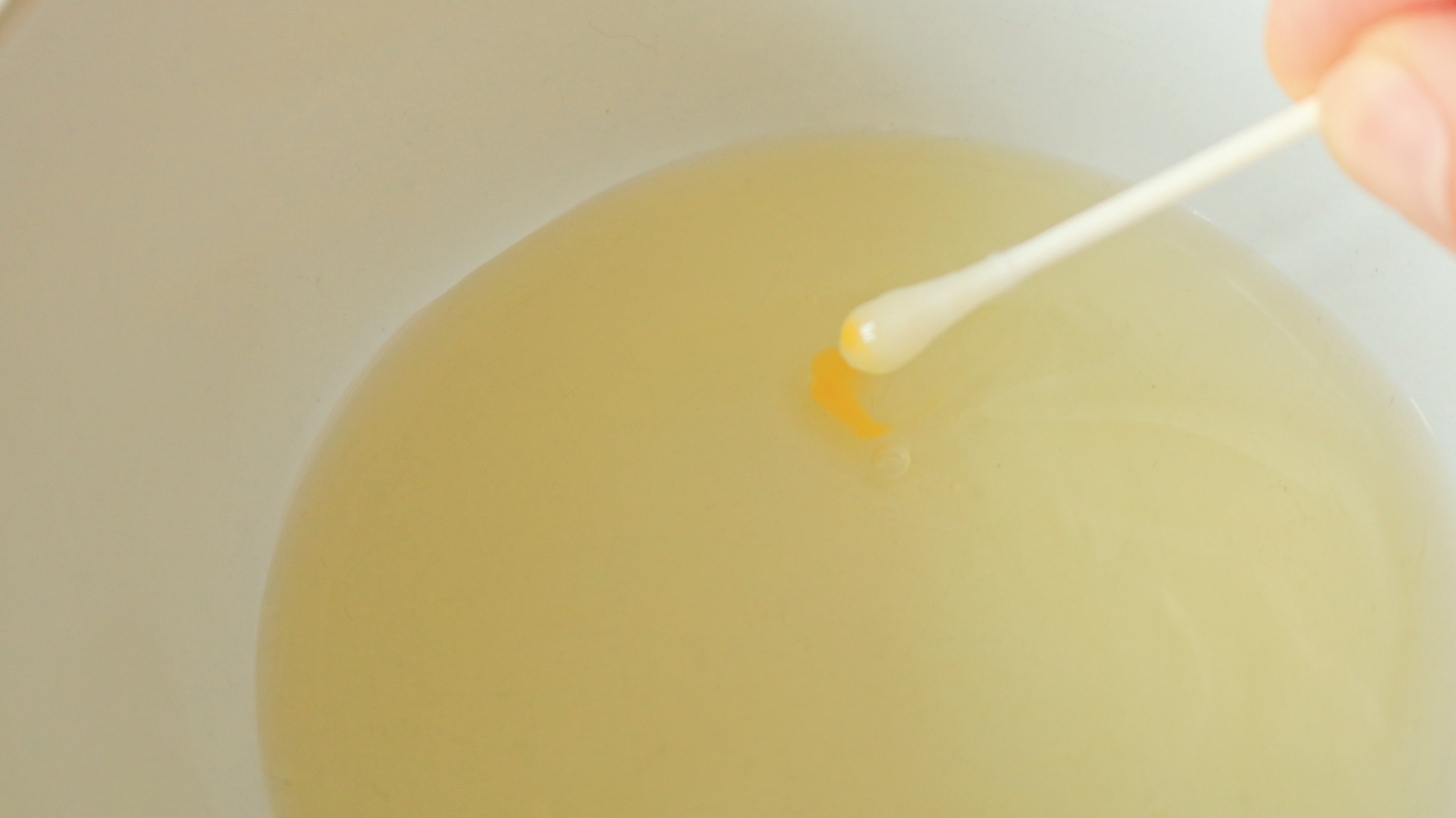 A cotton swab removing yolk from egg whites.